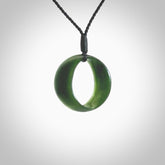 This little piece is a hand carved contemporary möbius ribbon disc pendant. Hand carved from New Zealand Kawakawa Jade. It has very subtle colour variations in the stone and is a delightful, small and artistic piece of jewellery. Hand made by Kyohei Noguchi and delivered to you in a kete pouch.